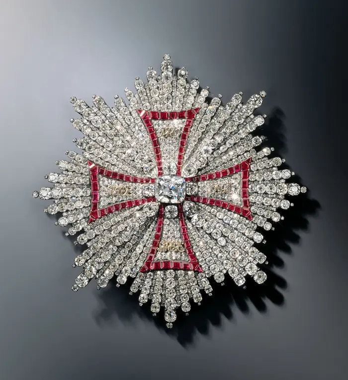 Diese Abbildung zeigt einen überreich mit Diamanten besetztes achteckigen Stern. In der Mitte befindet sich ein großer einzelner Diamant.