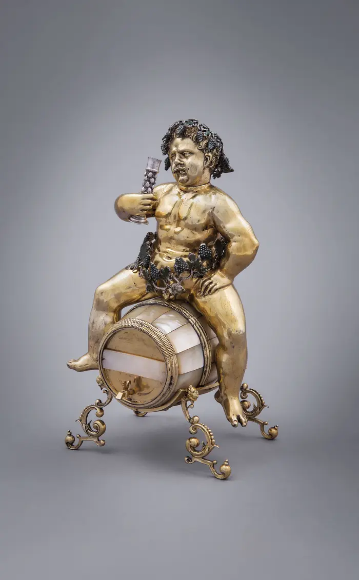 Figur mit einem Glas Wein in der Hand sitzt auf einem Weinfass