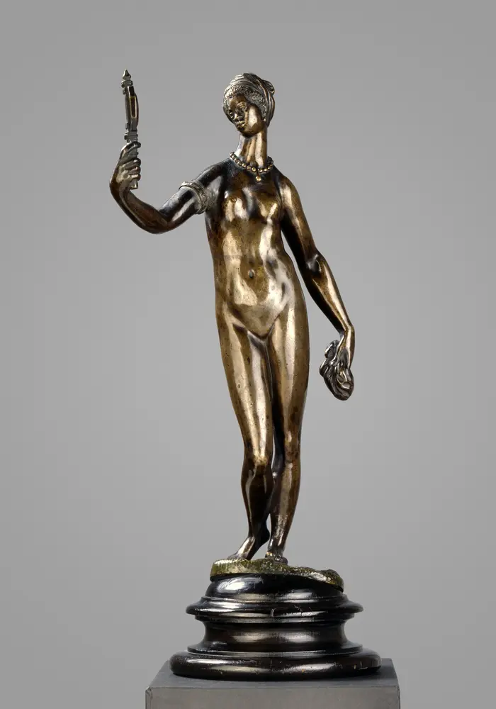 Vorderansicht einer Frau, die einen Spiegel in der rechten Hand hält und hineinschaut