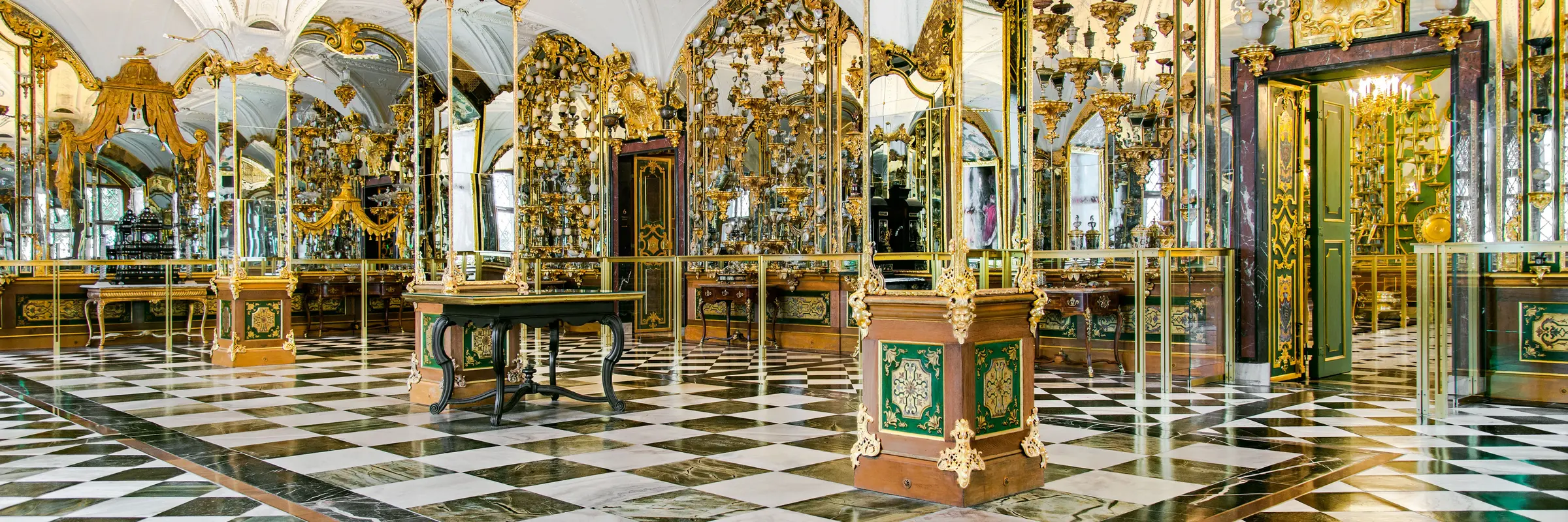 Blick in einen prunkvollen Raum mit Spiegeln und Ausstellungsstücken