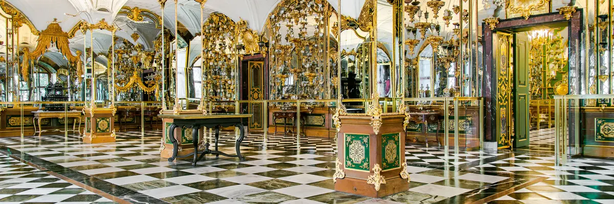 Blick in einen prunkvollen Raum mit Spiegeln und Ausstellungsstücken