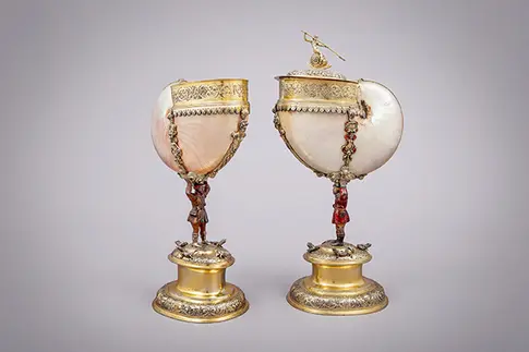 zwei große Muschelgefäße auf einem Sockel mit goldenen Verzierungen